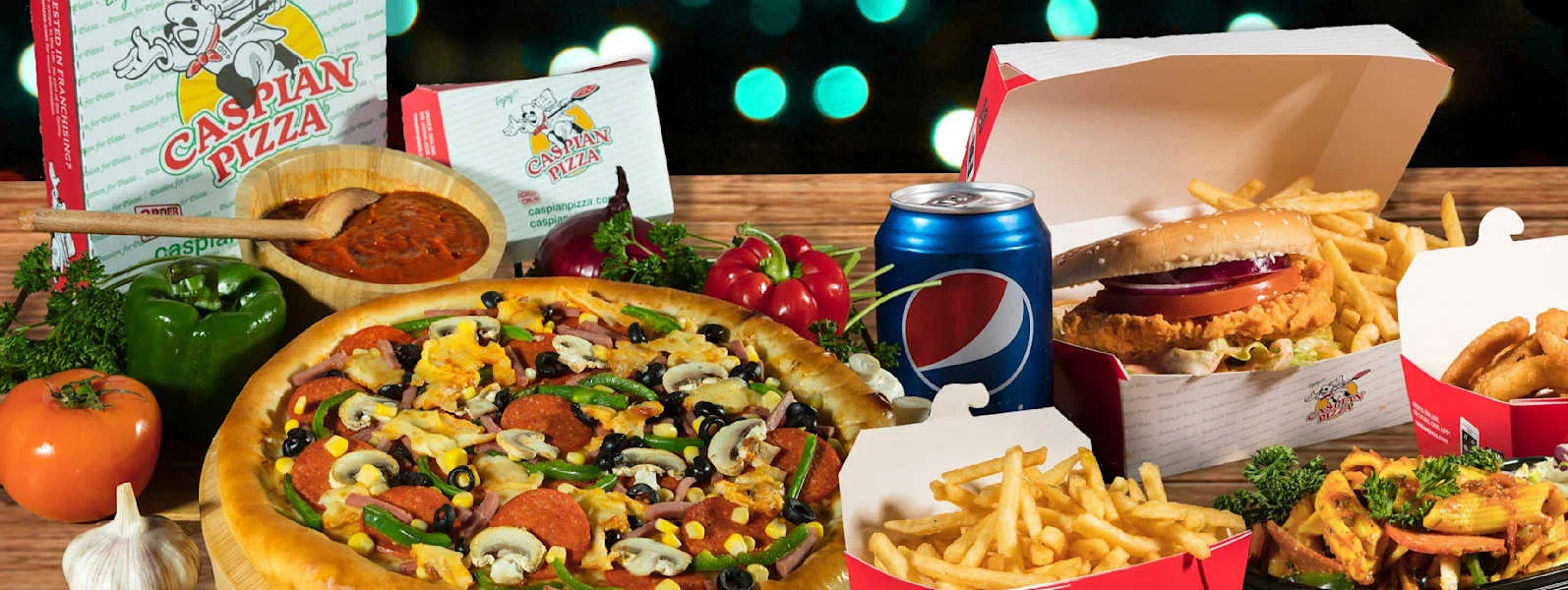 Caspian pizza, burgers, fries and sides on a table